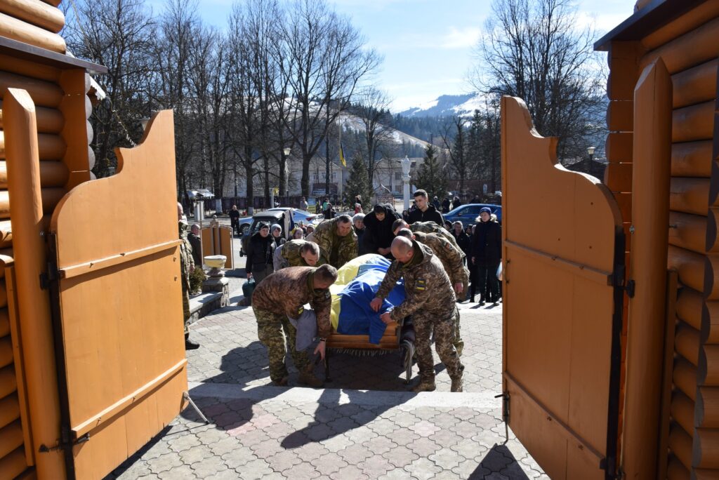 Військові несуть труну з українським прапором