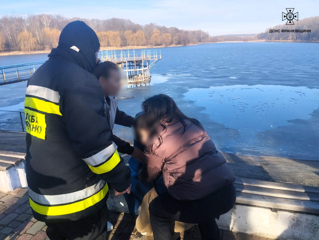 Рятувальники допомагають дитині на березі озера.