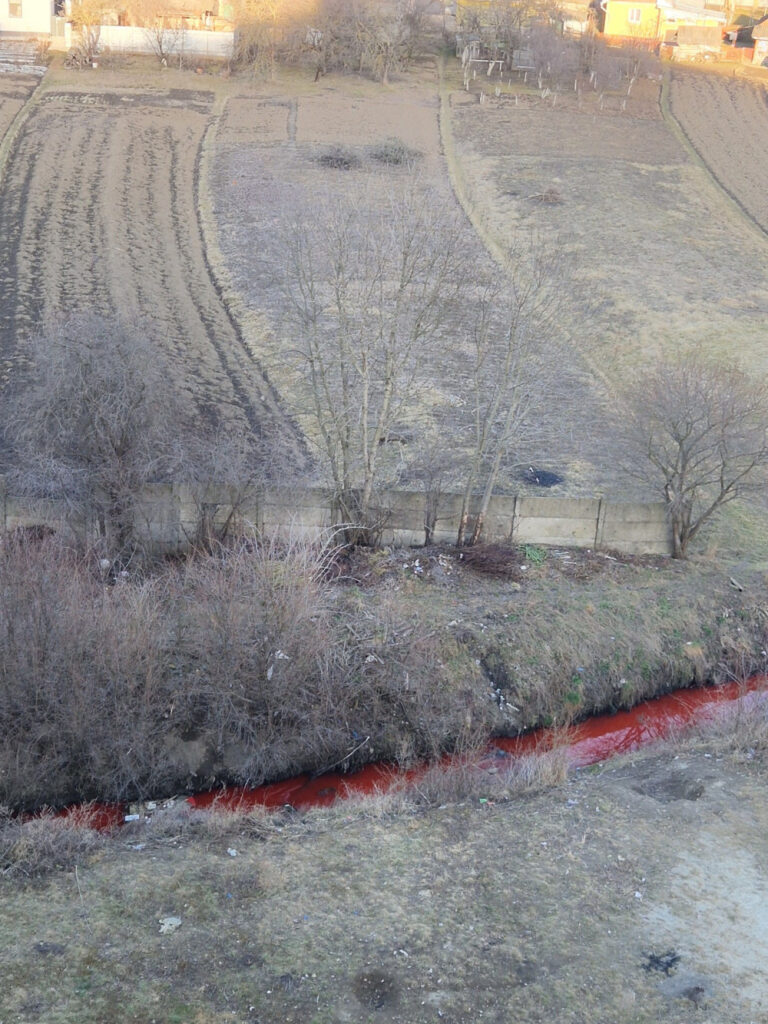 Червоний потік серед сільськогосподарських полів