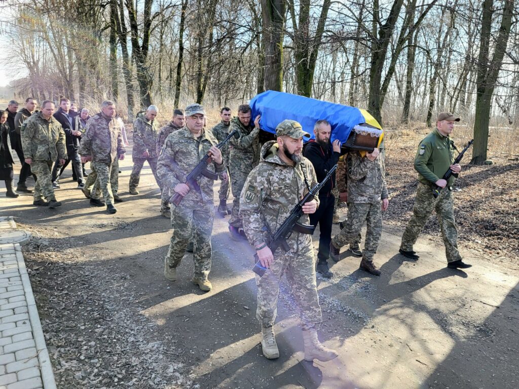 Військові несуть труну під прапором України на похороні.