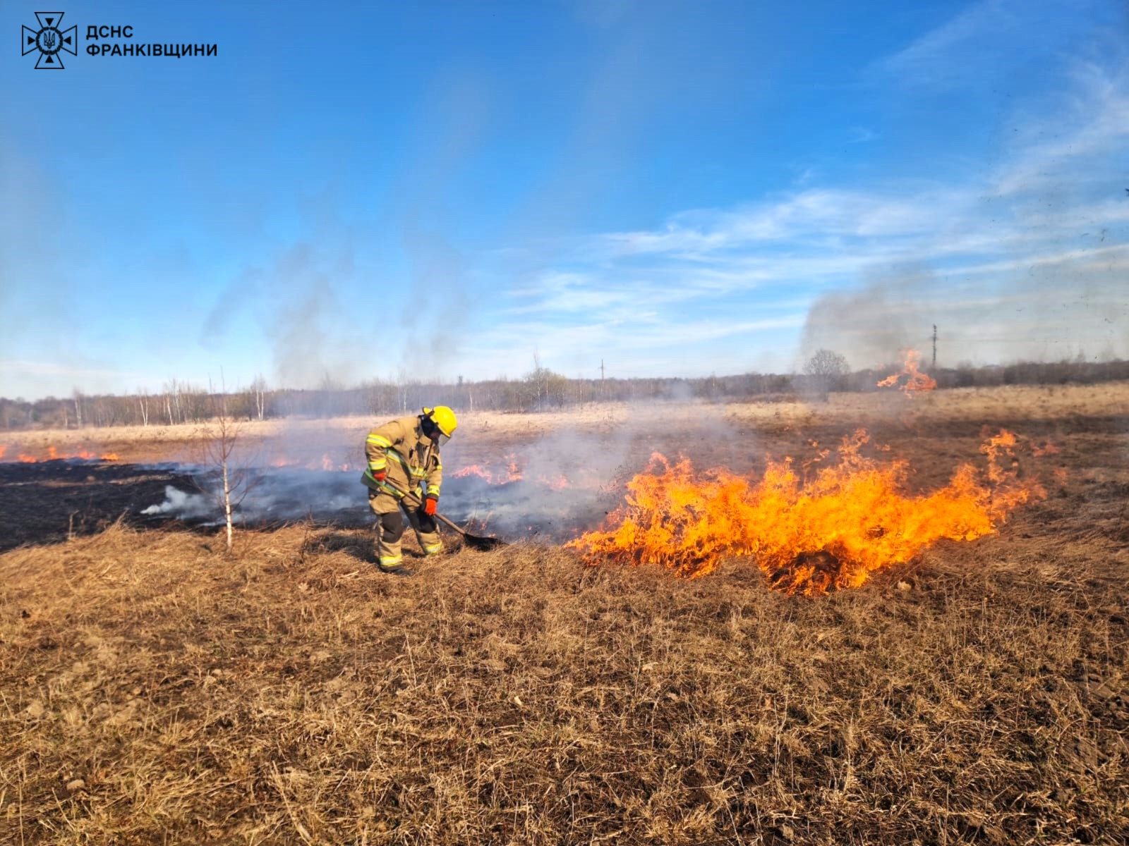 Пожежник гасить вогонь на полі в Україні.