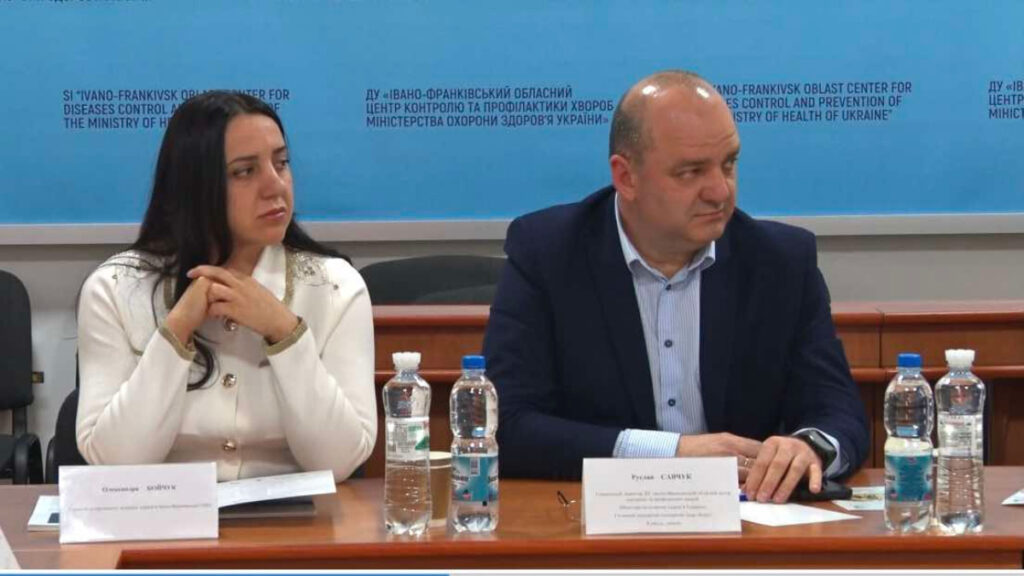 Двоє людей на конференції, сидять за столом