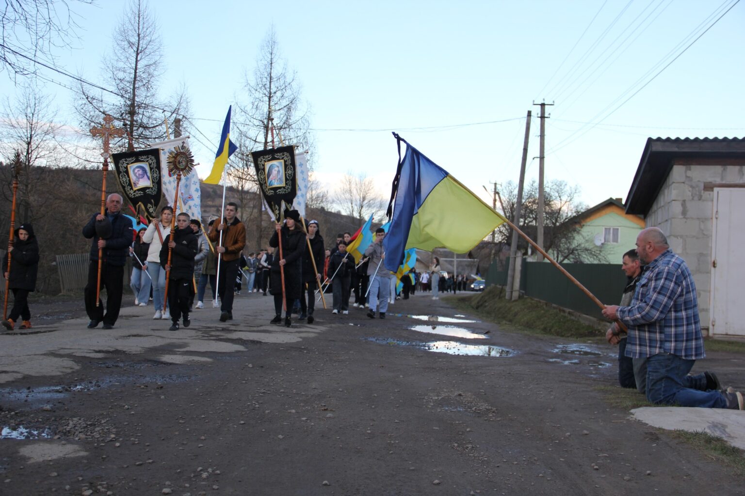 Хода селом з українськими прапорами та хрестами.