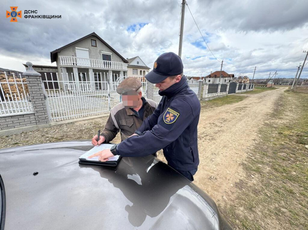 Представник служби ДСНС пише звіт на вулиці.