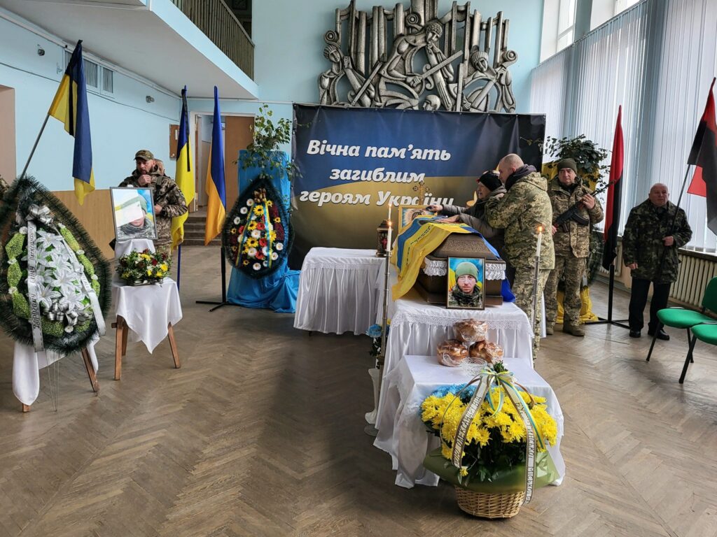 Церемонія пам'яті загиблого українського воїна з квітами.