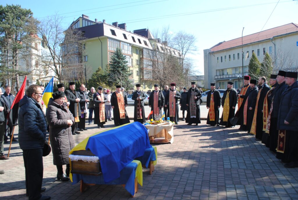 Церемонія прощання з військовими трунами на вулиці.