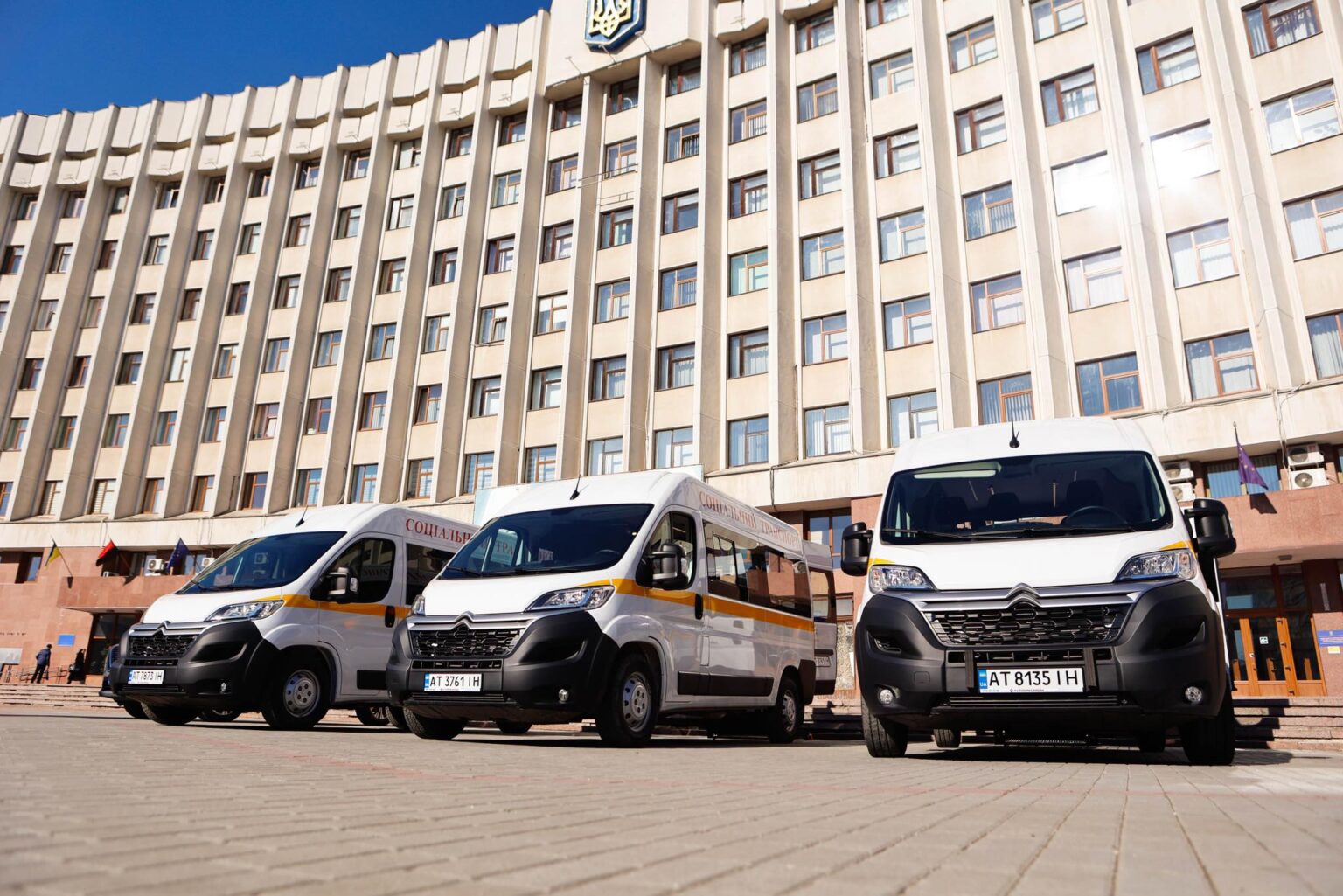 Білі мікроавтобуси перед адміністративною будівлею