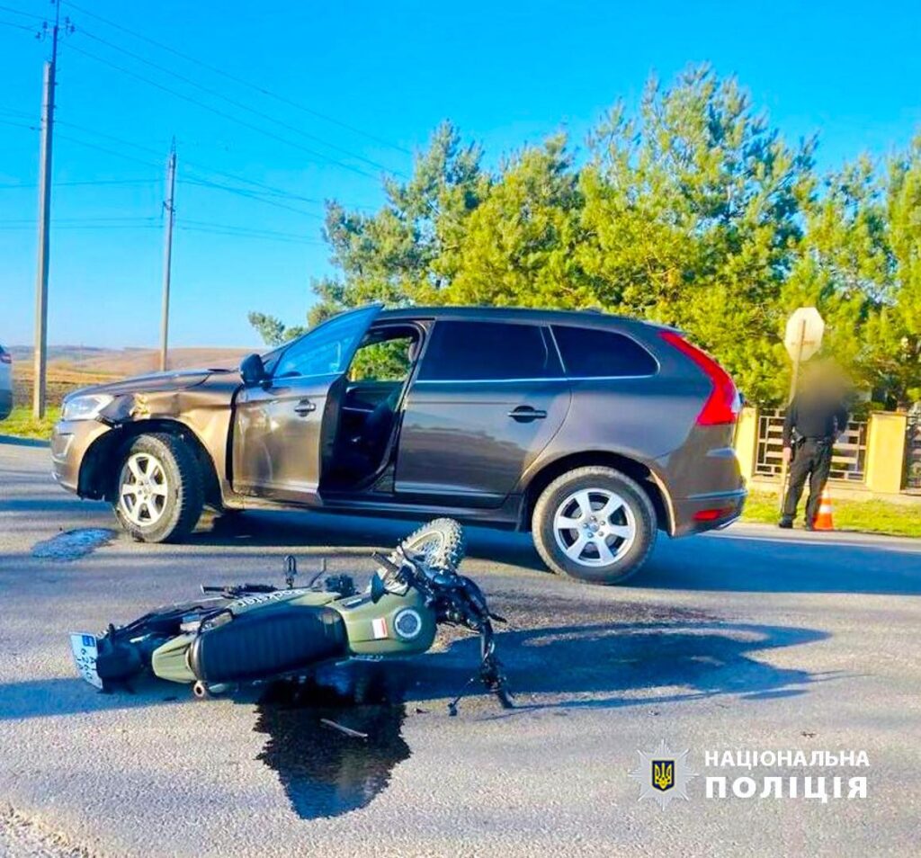 Зіткнення автомобіля з мотоциклом на дорозі.