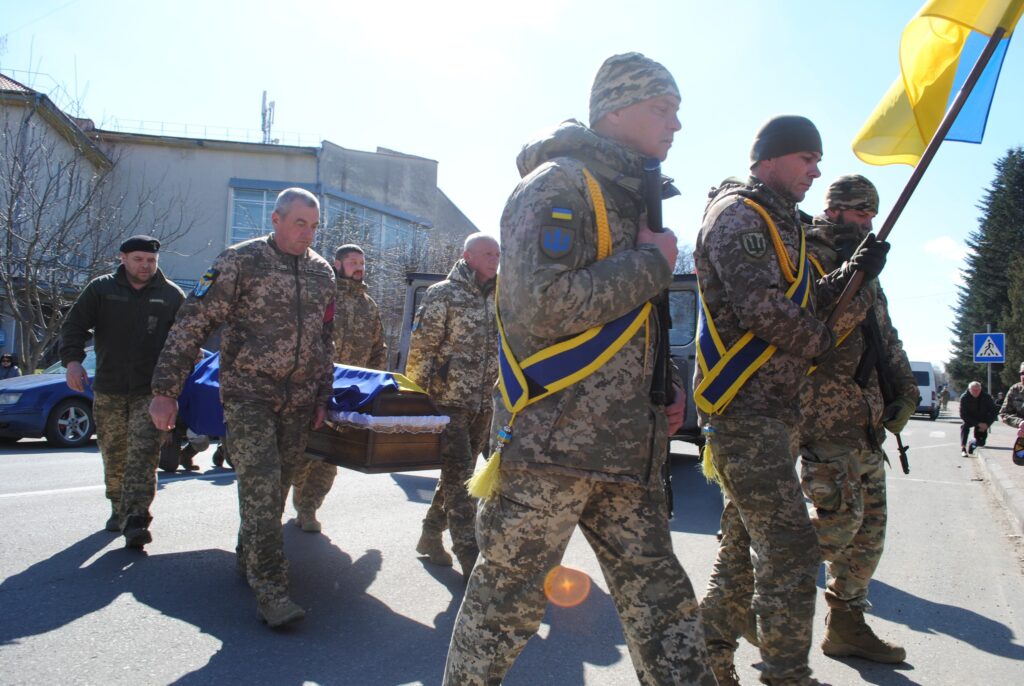 Військові несуть труну на вулиці