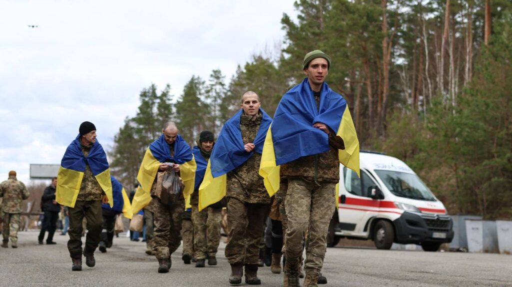 Українські солдати з прапорами на дорозі в лісі.