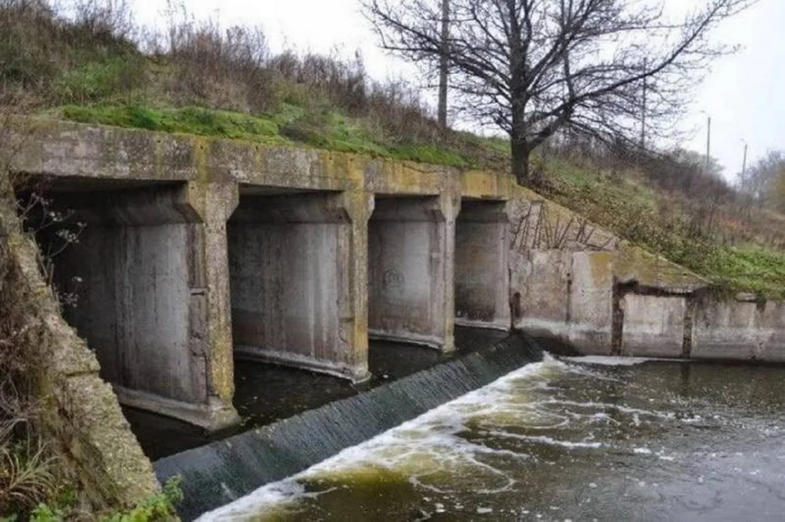 Стара бетонна дамба на річці в селі