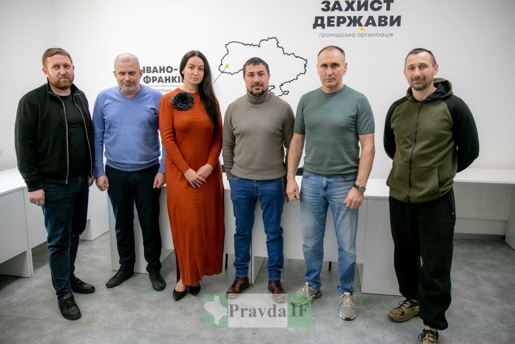 Групове фото людей на фоні логотипу організації