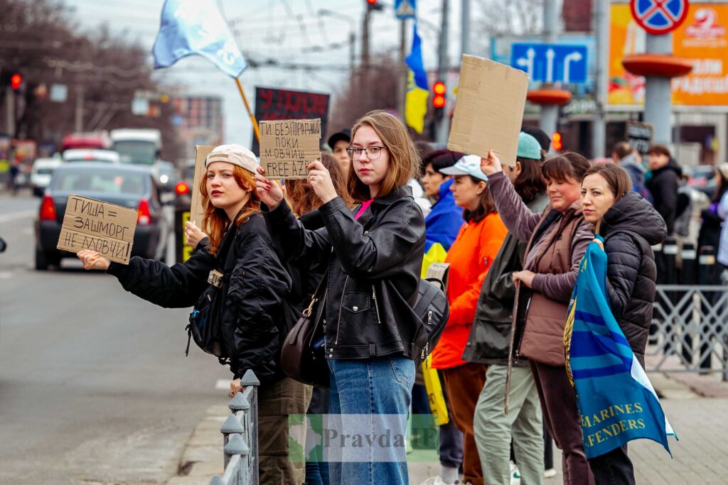 Протестувальники тримають плакати на вулиці міста.