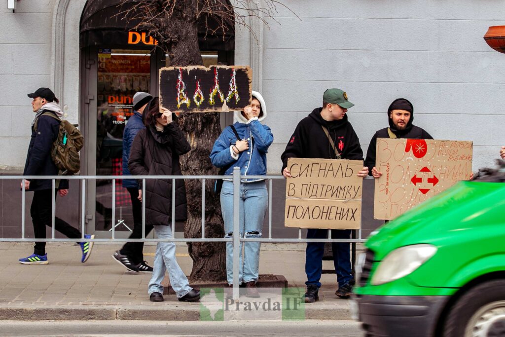 Люди тримають плакати на вулиці, підтримка полонених.