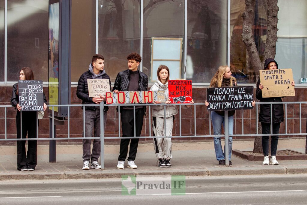 Люди з плакатами на вулиці підтримують військових.