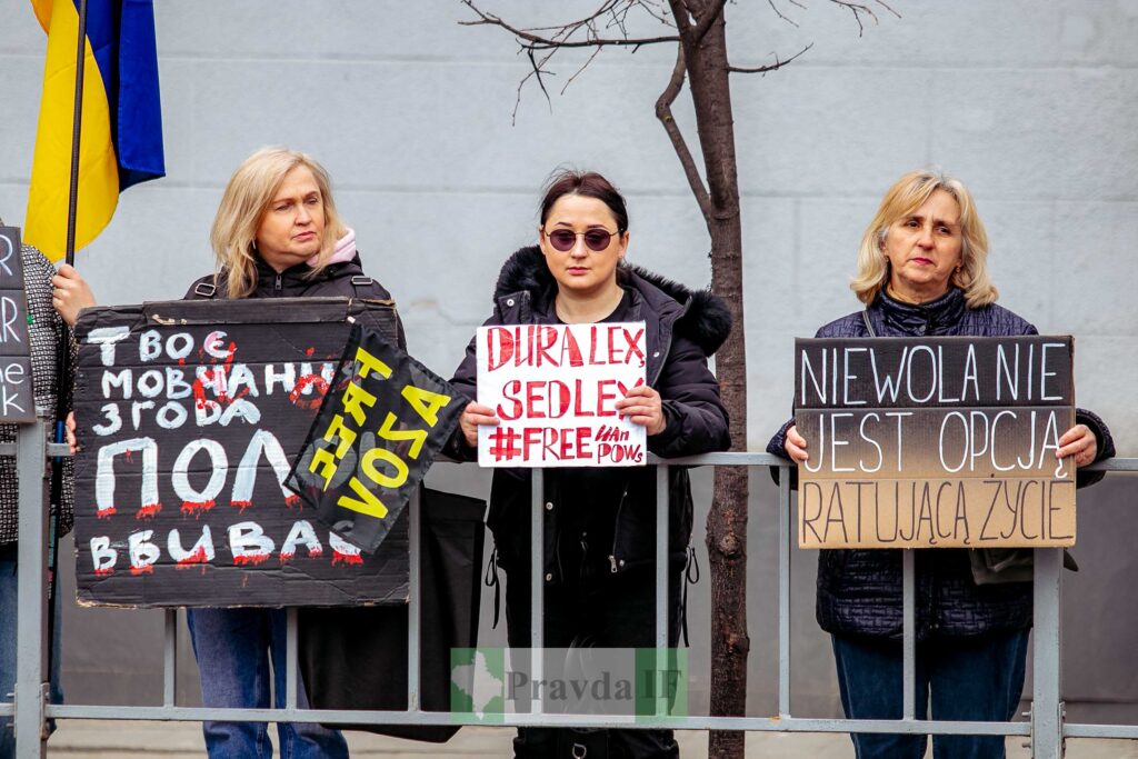 Три жінки тримають протести плакати на вулиці.