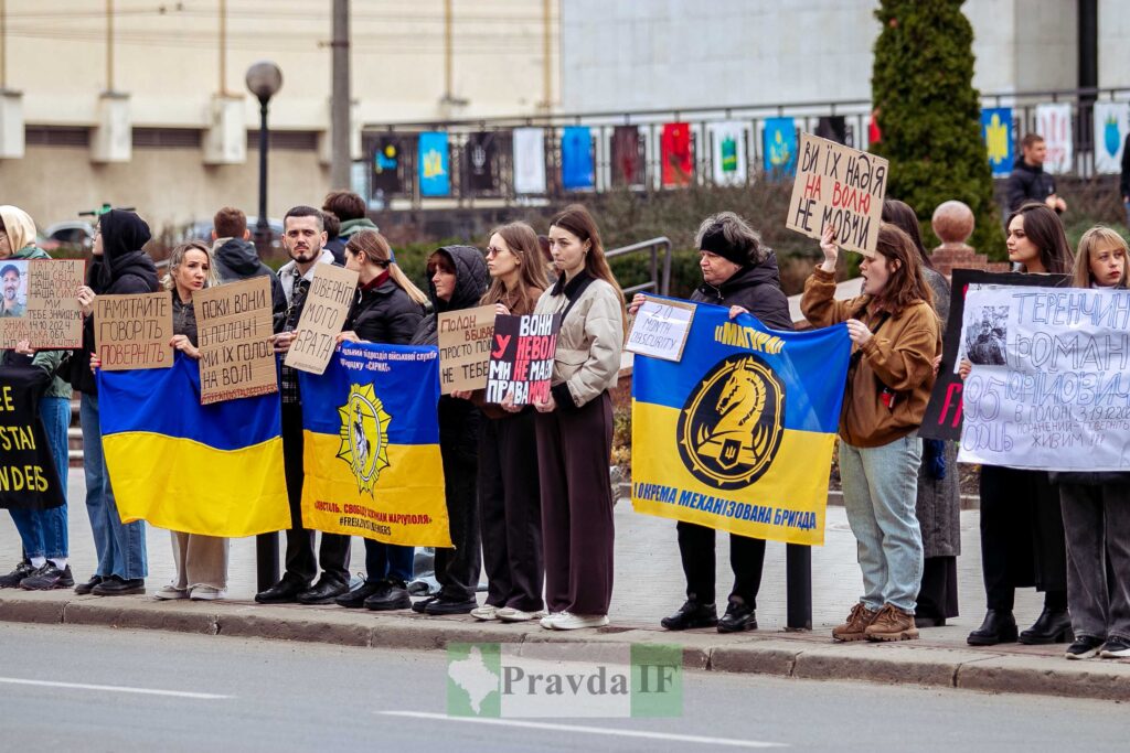 Протестуючі тримають плакати і прапори України.