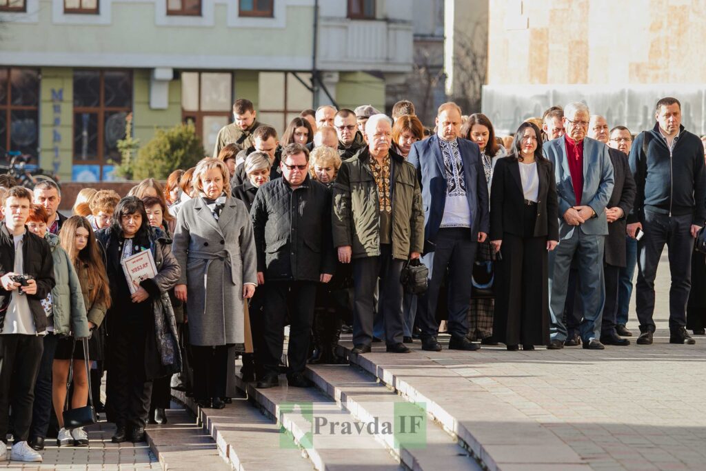 Група людей на сходах біля будівлі.