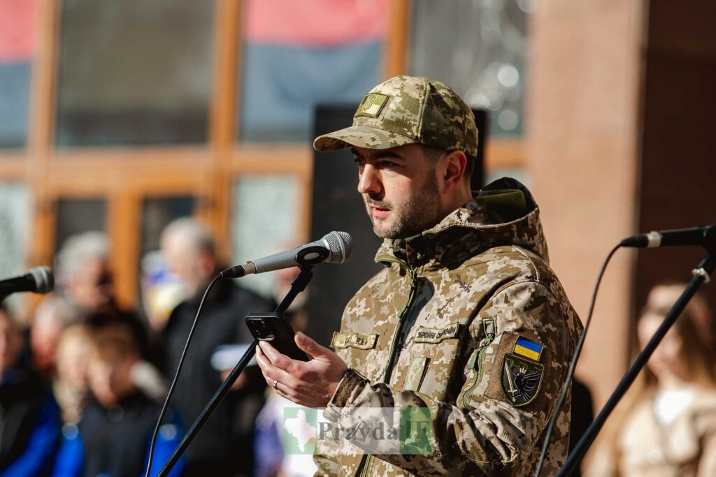 Український солдат промовляє на події перед мікрофоном.