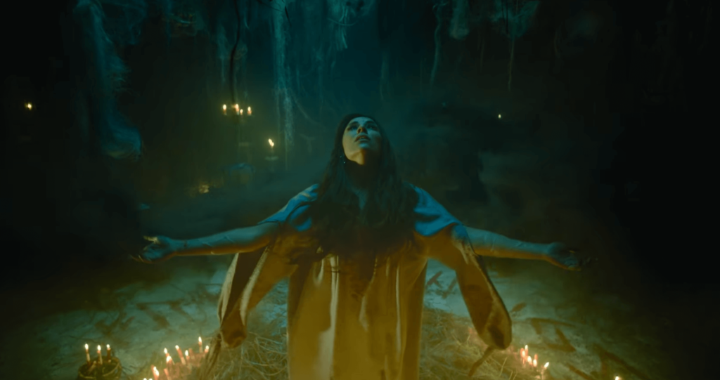 Жінка в пещері з свічками у колі ритуалу