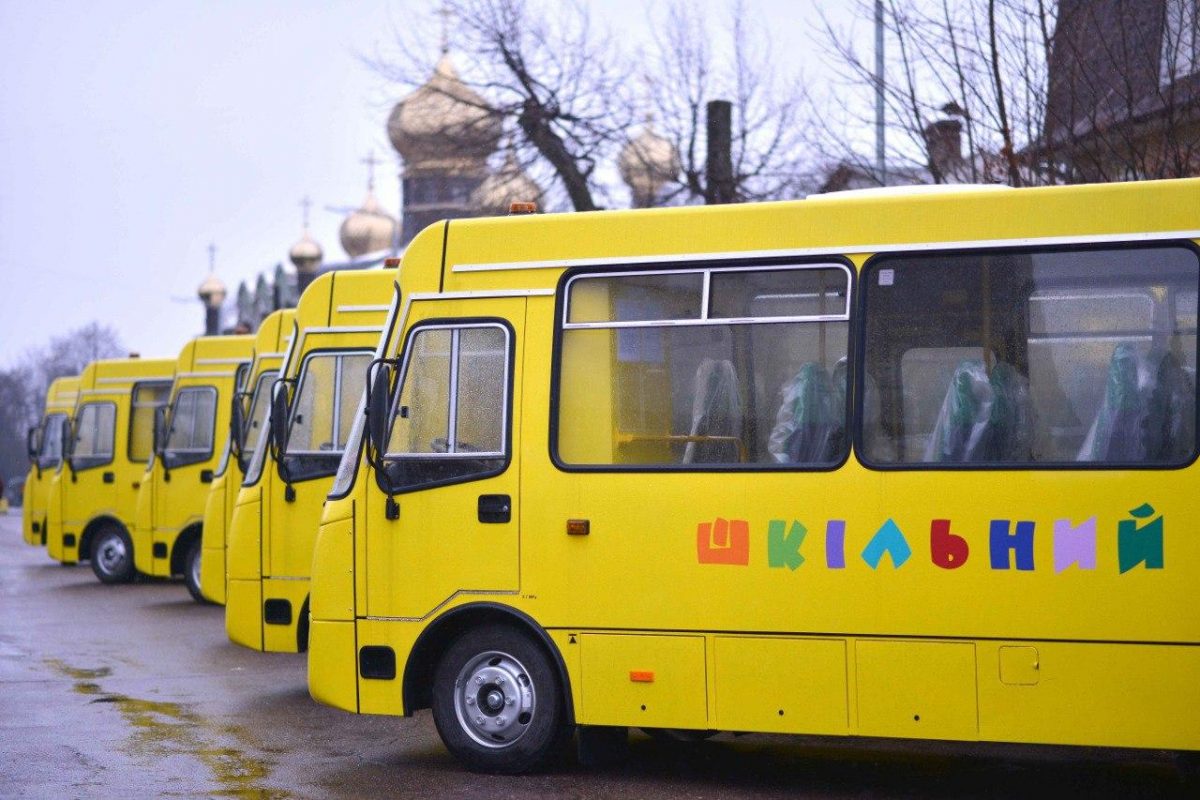 Жовті шкільні автобуси в ряду на вулиці.