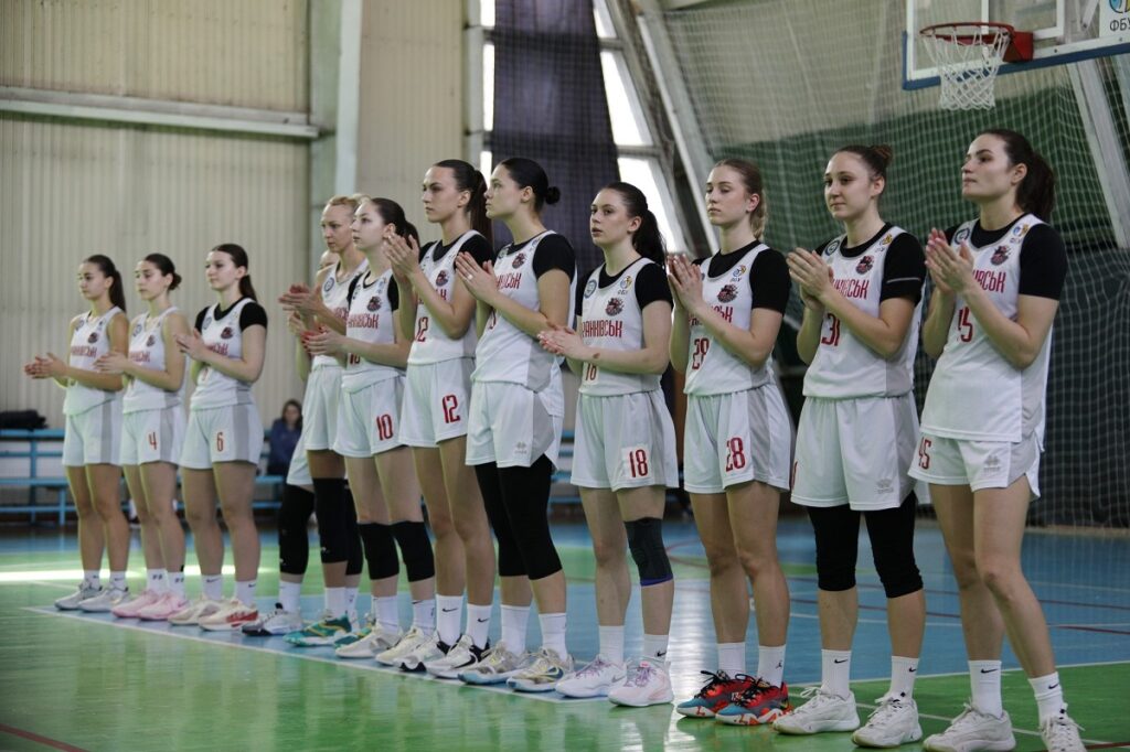 Жіноча баскетбольна команда на майданчику, аплодують.