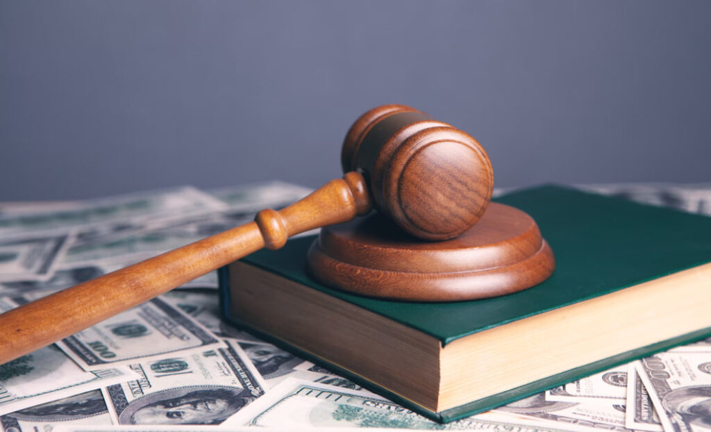 Суддівський молоток на книзі і грошах