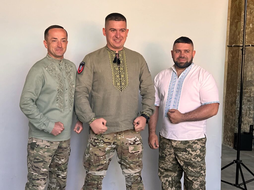 Троє чоловіків у військових штанах та вишиванках