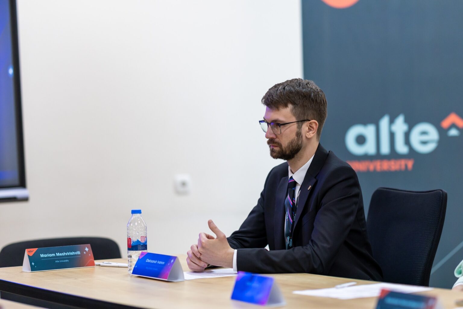 Чоловік у костюмі на конференції в університеті.