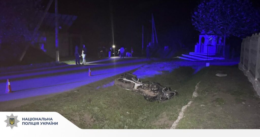 Нічна дорожня аварія з мотоциклом, поліція на місці.