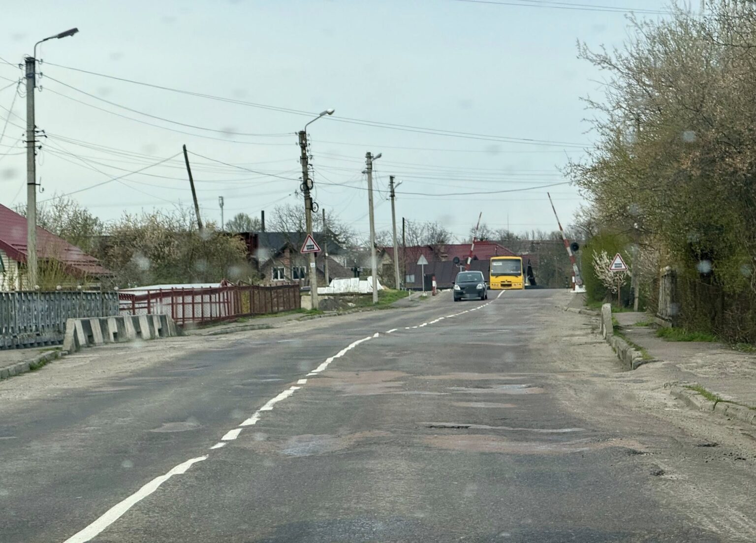 Дорога з автомобілями та залізничним переїздом.