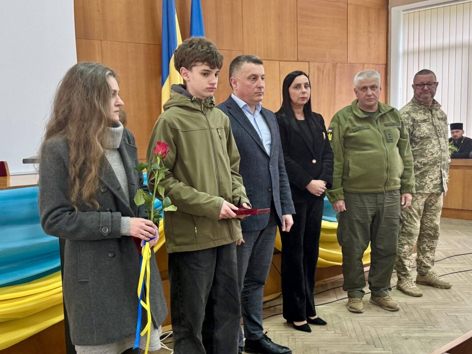 Церемонія нагородження на фоні прапорів України.