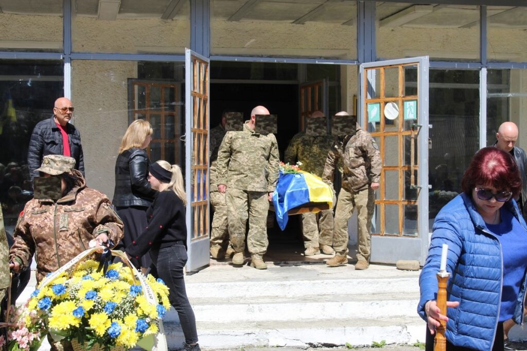 Церемонія прощання з військовим у камуфляжі.