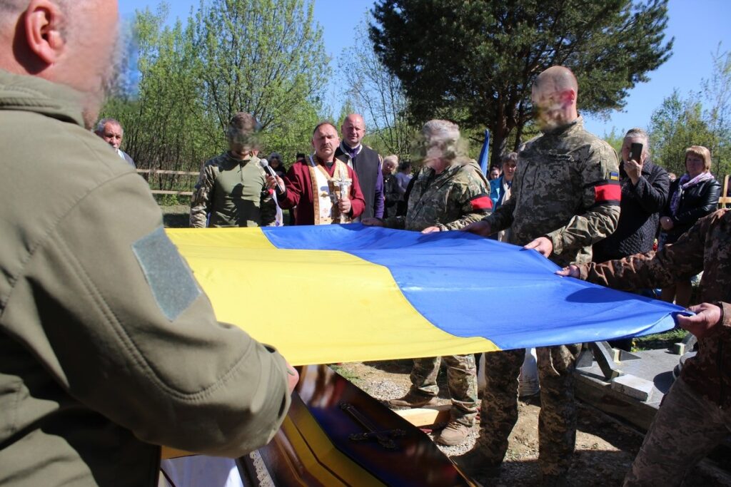 Військові тримають український прапор на церемонії.