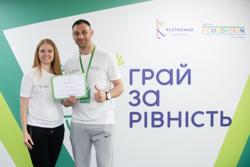 Люди з сертифікатом на фоні логотипів.