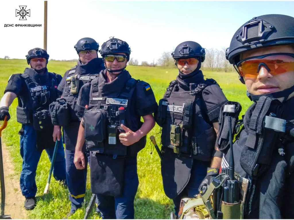 Рятувальники на полі в захисному спорядженні.