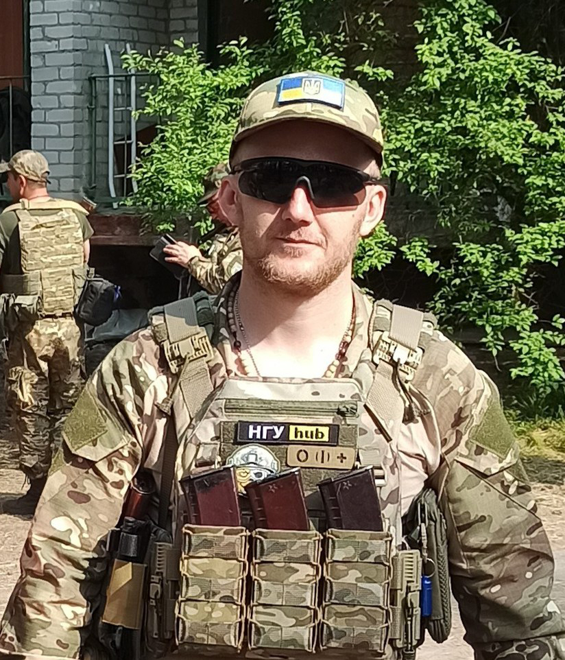 Військовий в камуфляжі з нашивкою прапора України.