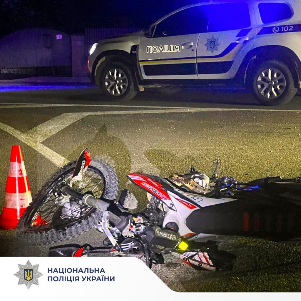 ДТП: Поліцейська машина та перевернутий мотоцикл на дорозі.