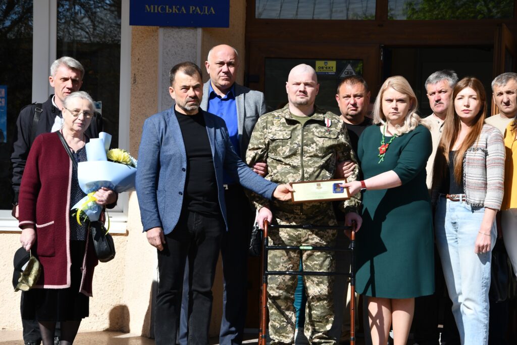 Група людей біля міської ради отримує нагороду.