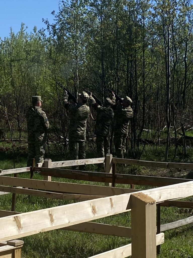 Військові у камуфляжі стріляють у лісі.