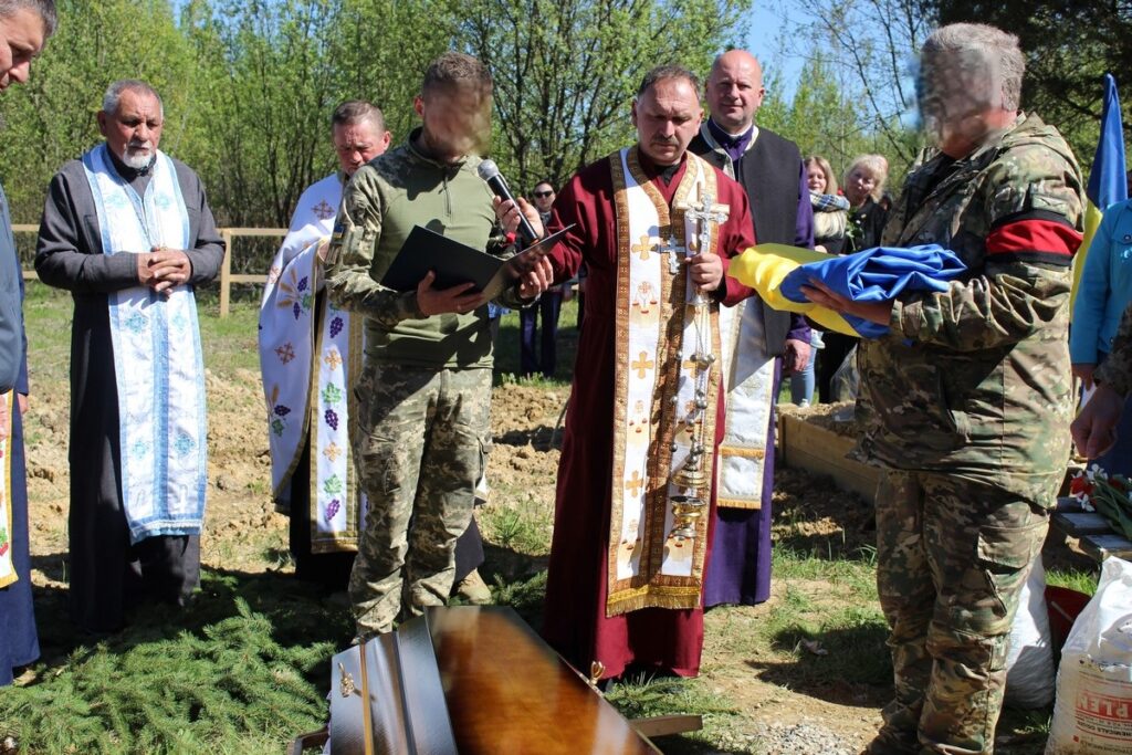 Військове поховання з церковною службою на кладовищі.