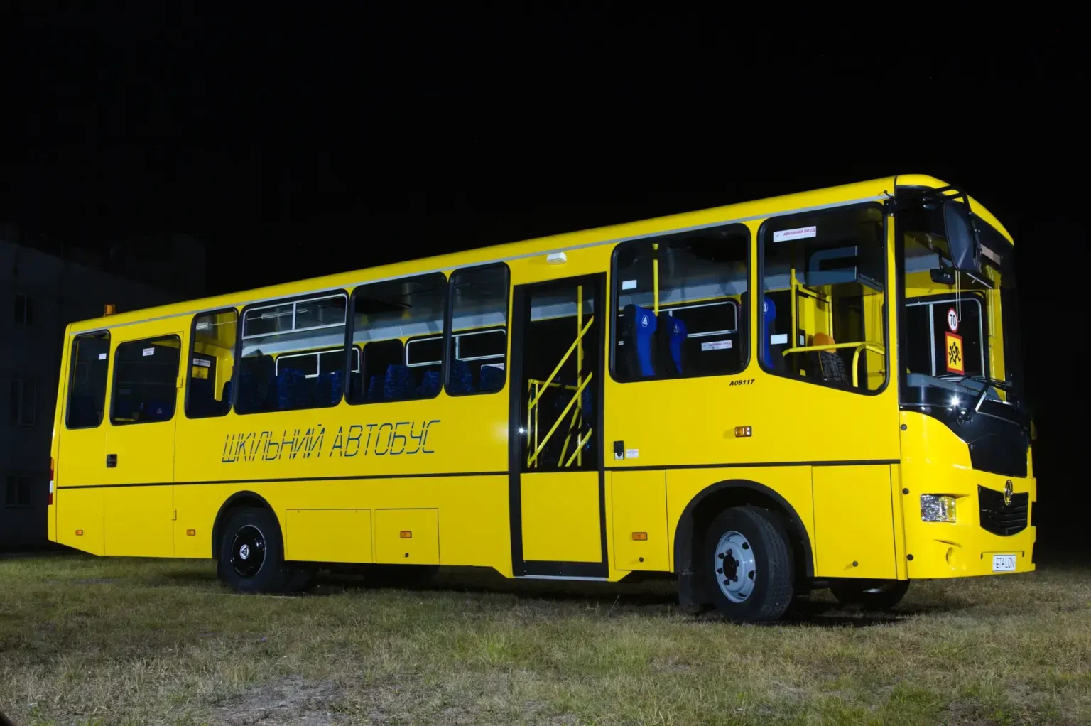 Жовтий шкільний автобус вночі на траві