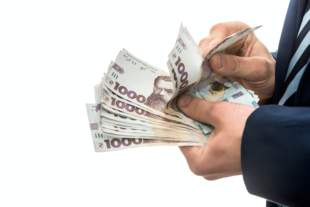 Людина рахує гроші, гривні, 1000 купюри.