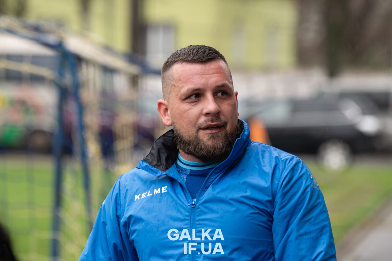 Чоловік у синій куртці на вулиці