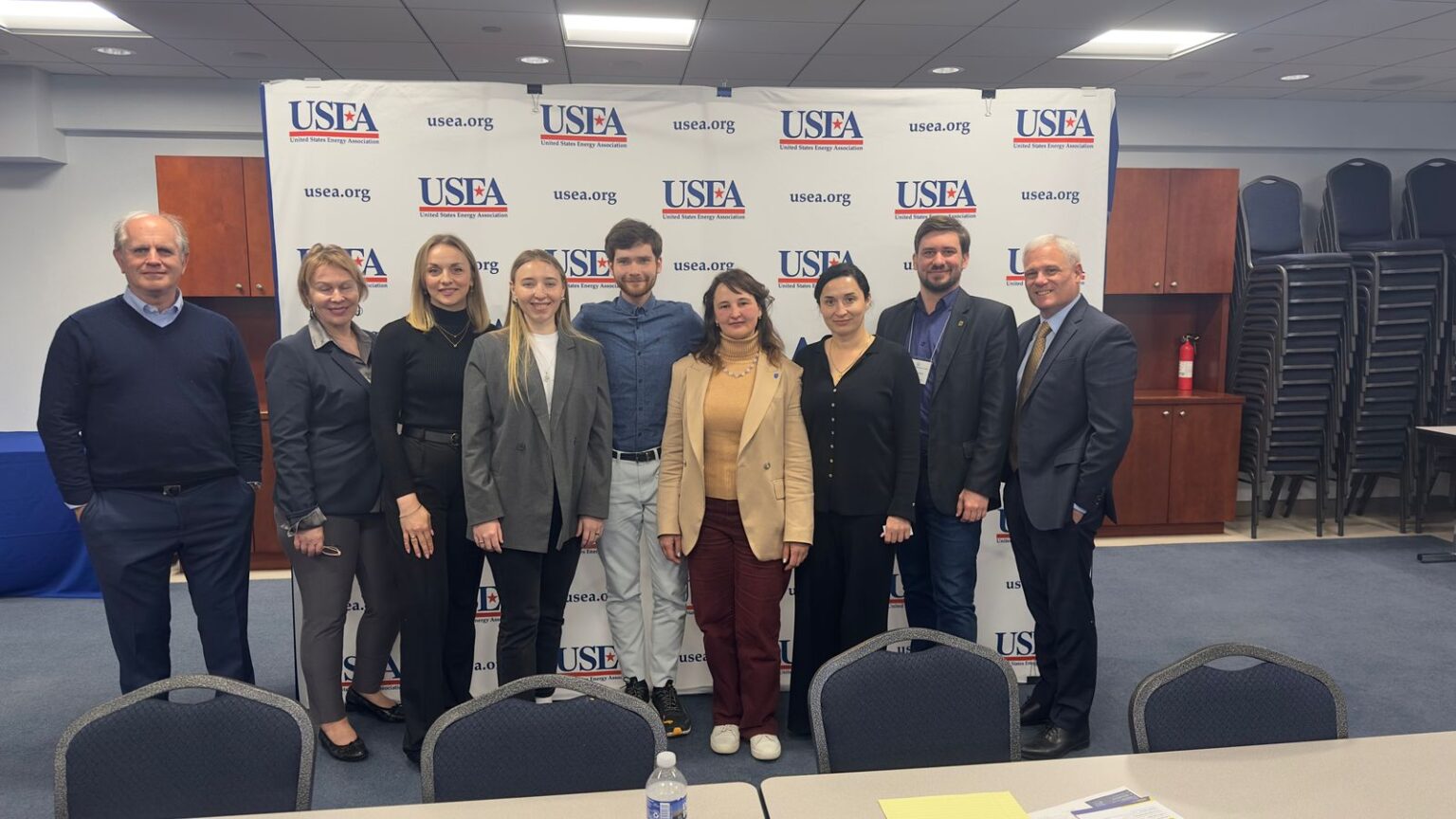 Група людей стоїть перед банером USEA