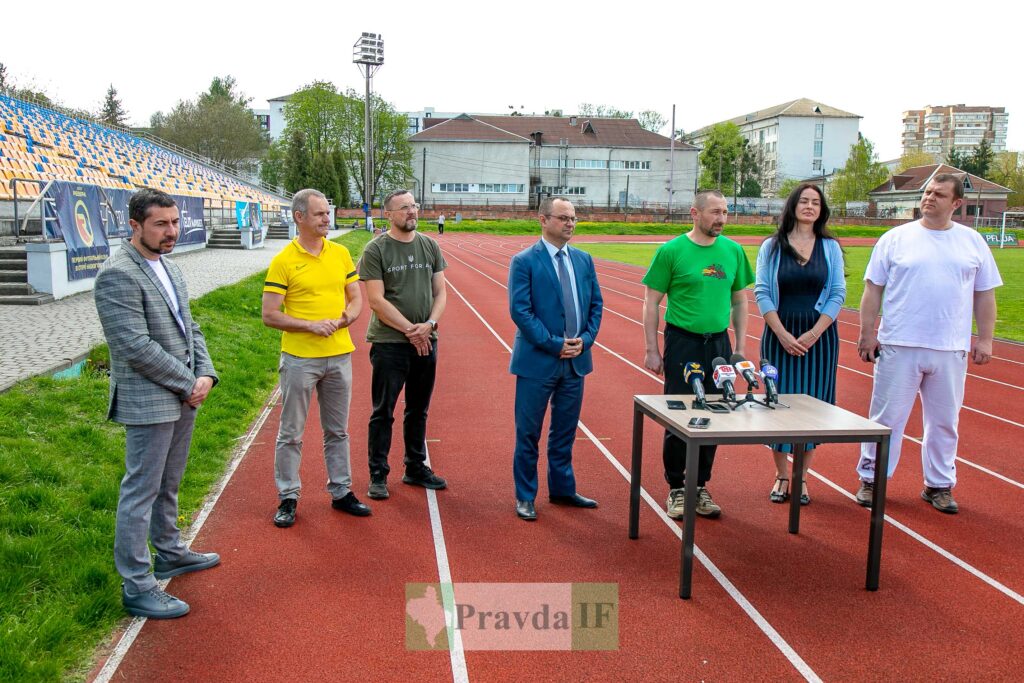 Група людей на стадіоні дає прес-конференцію