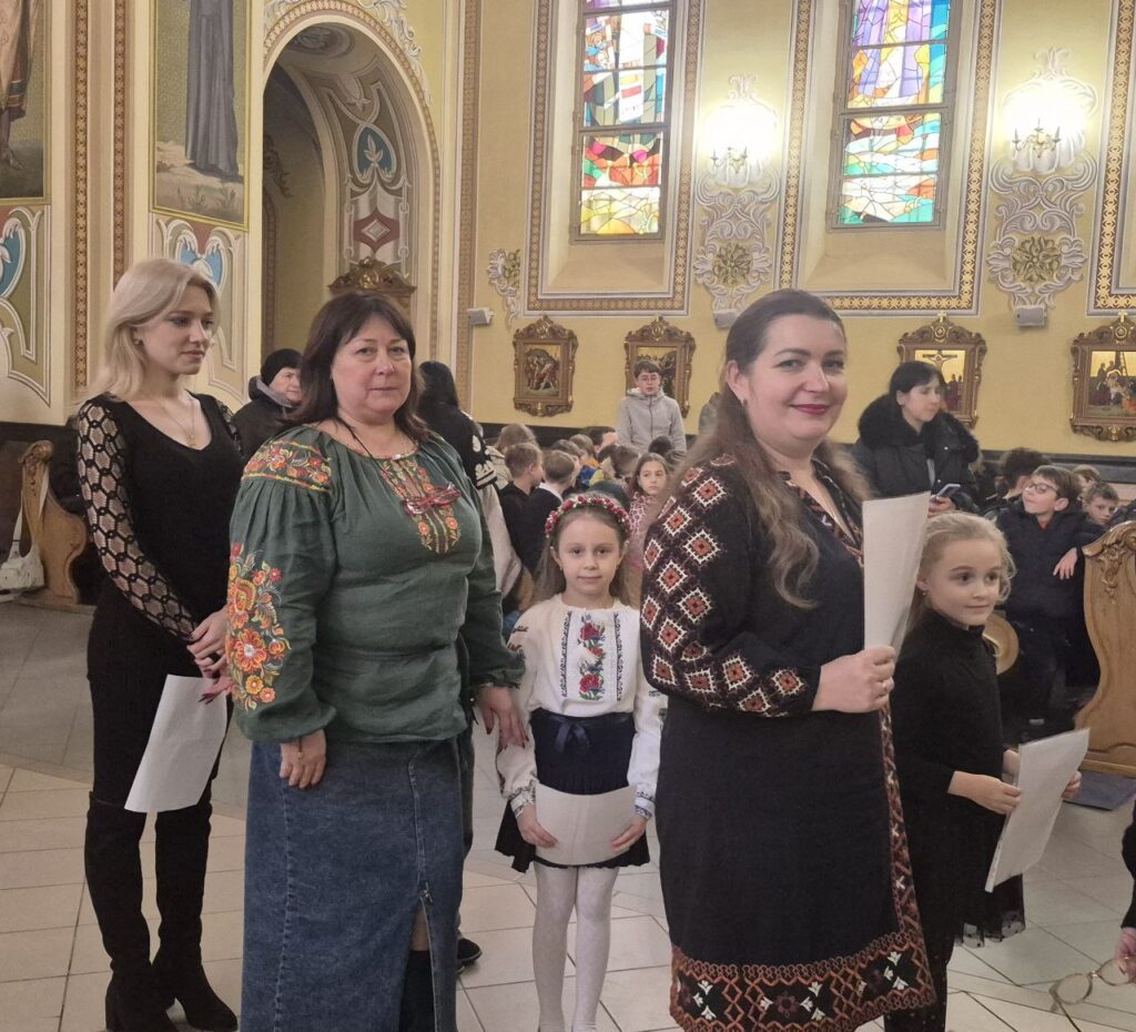 Люди у вишиванках стоять в церкві.