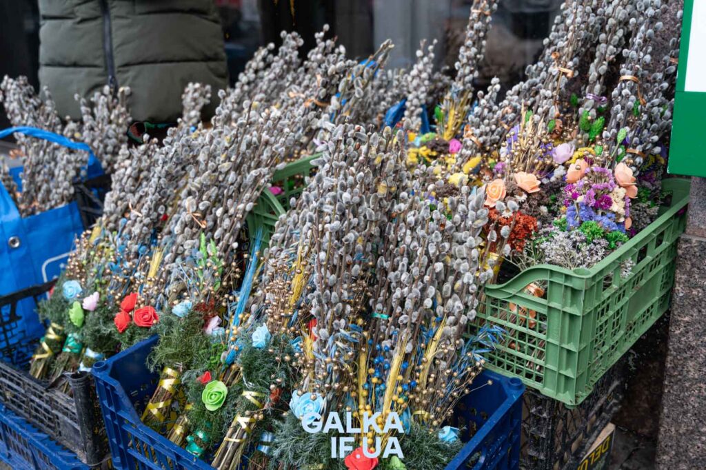 Квіти та вербові гілки в пластикових ящиках