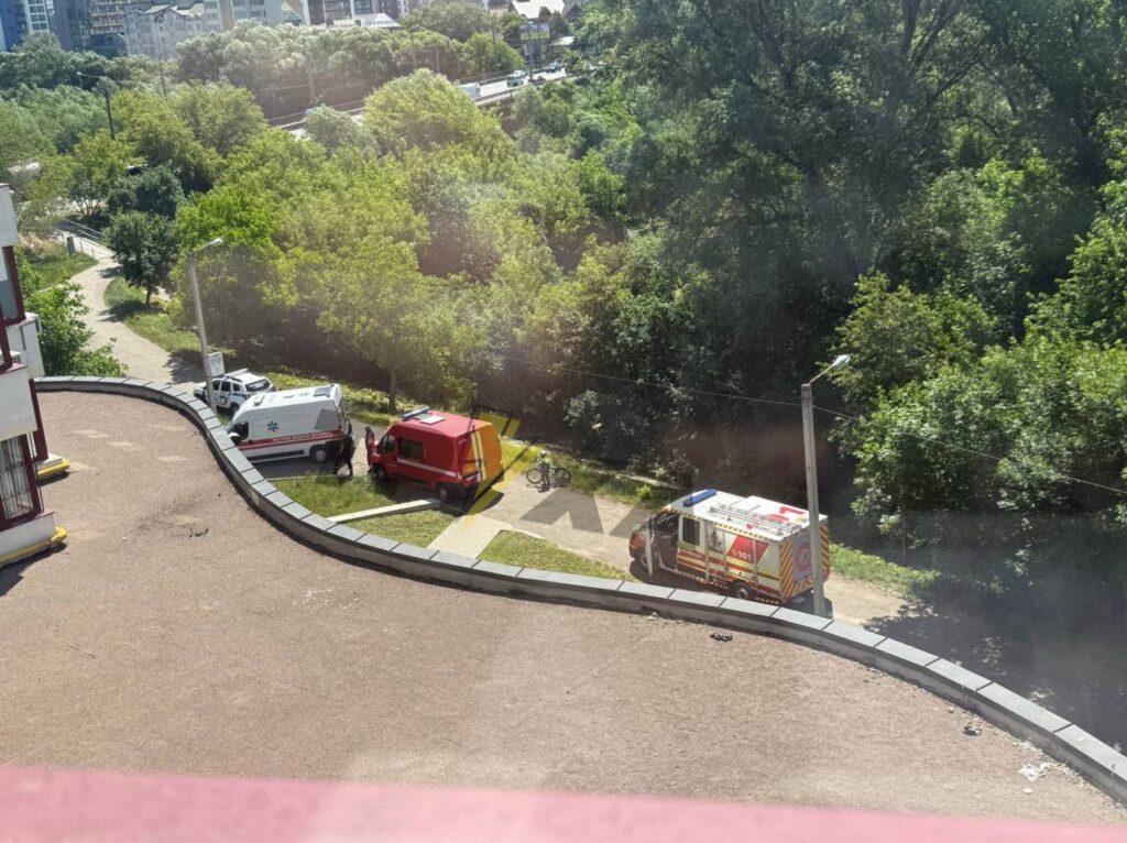 Три машини швидкої допомоги біля лісу.