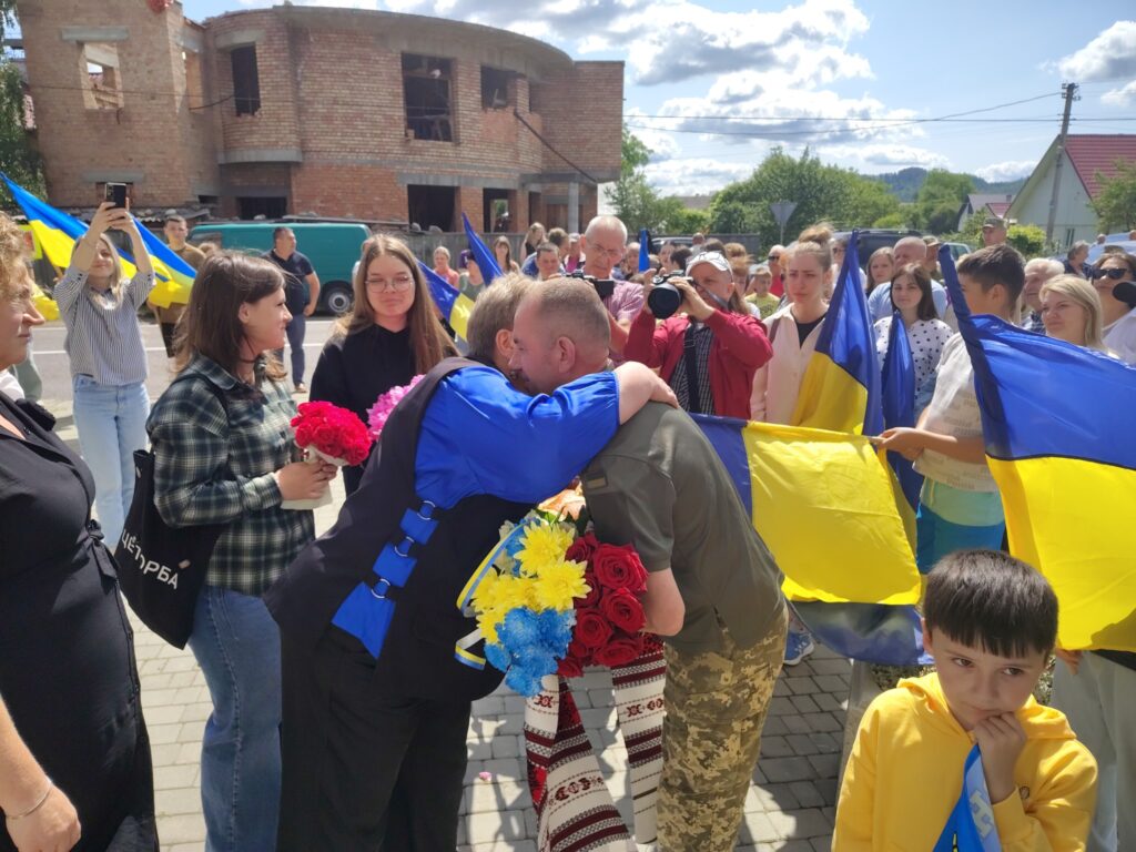 Люди піднімають прапори України на вулиці.